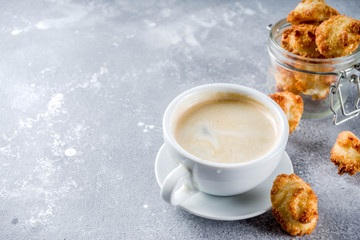 French coconut cookies congolais with coffee mug, grey stone or concrete background copy space