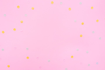 Pink pastel festive background with multicolored confetti. Copy space for your text. Flat lay style. Top view. 