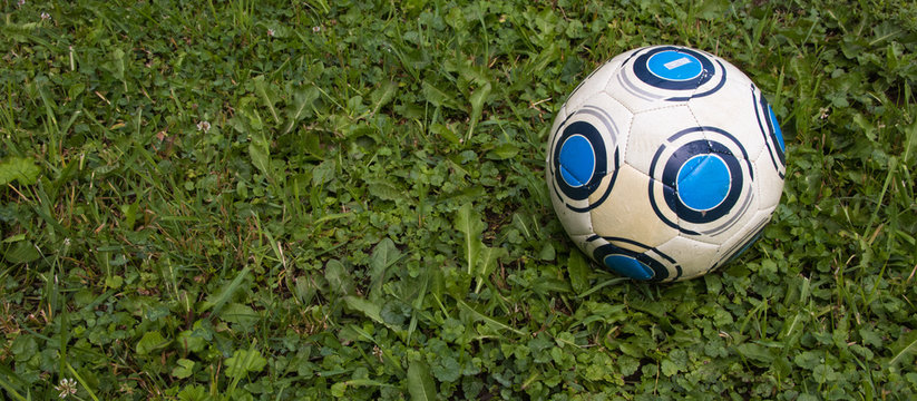 Soccer ball or football ball on green field. Leather soccer ball  on clover field close up. Selective focus