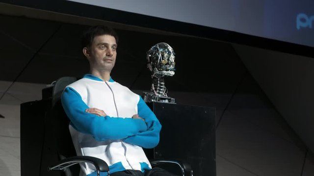 Humanoid robot man on stage. Innovative development in robotics and artificial intelligence. Android Presentation. Modern Robotic Technologies. The robot shows emotions.