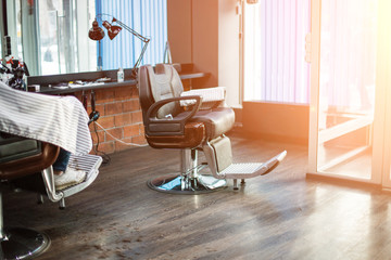 Hairdressing armchair. modern hair salon for men. Workshop of hairdressers. Beauty salon with chairs, hair dryers, combs and mirrors. Barbershop 