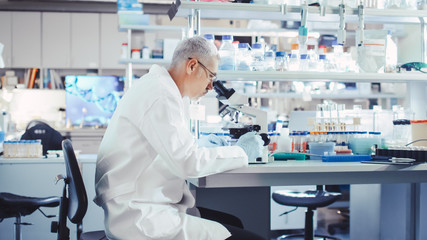 Senior Male Research Scientist is Working with Electron Microscope in a Modern High-Tech...
