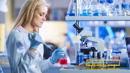Blond Research Genetic Woman Scientist is Holding a Micro Pipette and Preparing Sample for...