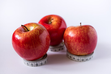 red apples and measuring tape isolated on white