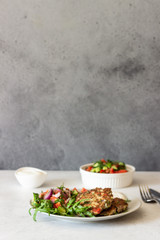 Chicken or turkey cutlets with vegetables and sauce on a plate. Delicious cutlets with salad. Selective focus.