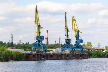 Russia, Moscow August 2018: Unloading of the barge with crushed stone port cranes in the port.