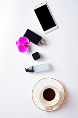 cup of coffee with smart  phone and lady care set around white background. life style flat lay