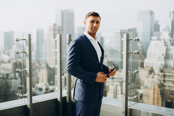 Fototapeta premium A successful business man smiles at the roof of a modern building