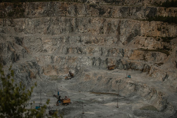 Cement production factory on mining quarry. Conveyor belt of heavy machinery loads stones and gravel. Industrial background with working gravel crusher