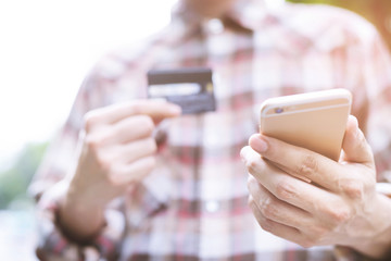 young business man hands holding credit card and using phone. Online shopping purchase Sell or Payment. filler vintage.