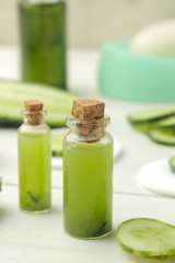 Cosmetics with cucumber extract and fresh cucumber on a white wooden table. spa. beauty.