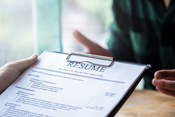 Interviewer reading a resume, Person submits job application, Person describe yourself to interviewer, focus on resume, recruiter considering application, hr manager making hiring decision