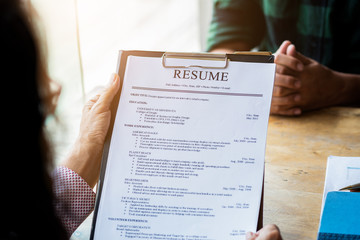 Obraz premium Interviewer reading a resume, Person submits job application, Person describe yourself to interviewer, focus on resume, recruiter considering application, hr manager making hiring decision