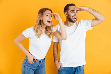 Excited cheerful young couple standing isolated