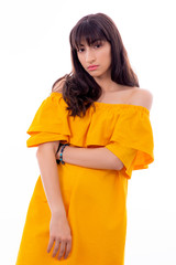 Portrait of Attractive Young Female Model. The girl poses with a yellow dress in a studio with a white background.