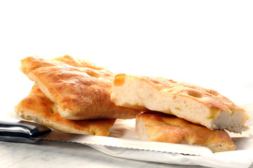 slices of traditional italian focaccia and a knife rest on a marble table with copy space for your text