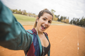 Sporty woman taking selfie on stadium track