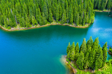 Mountain forest lake landscape. Aerial view. View on the turquoise color lake between mountain forest. Over beautiful turquoise mountain lake and green forest. National park. Green pine and fir trees