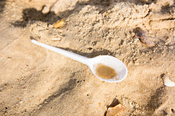 Plastic spoon on a sandy beach pollution trash