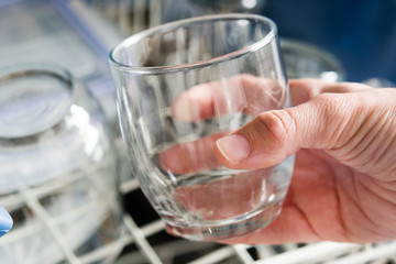 woman taking a glass out of the dishwasher