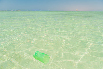plastic bottle part flowing in clear blue sea coast water