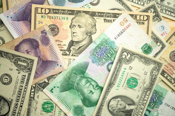 US dollar stack and Chinese yuan banknotes on the table The concept of a trade war between the United States and China