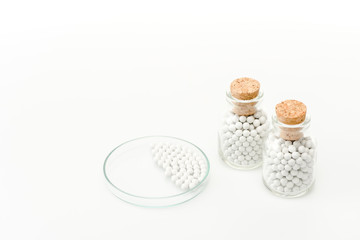 bottles with wooden corks near glass petri dish isolated on white