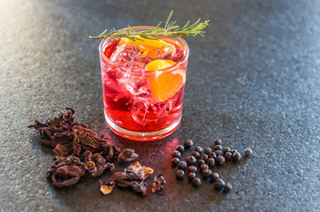 Beautiful hibiscus kombucha cocktail with gin and vodka, decorated with rosemary branch.