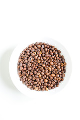 coffee beans brown closeup with blurred background in white plate on white isolated background