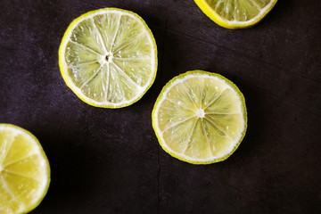 Round lime slices on a black background. Ingredient for smoothies. Background image. Concept of...