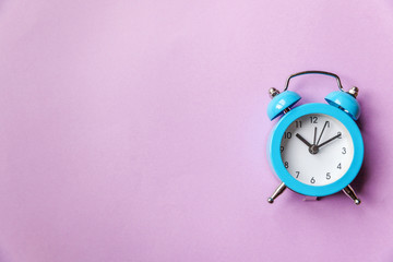 Ringing twin bell vintage classic alarm clock Isolated on purple violet pastel colourful...