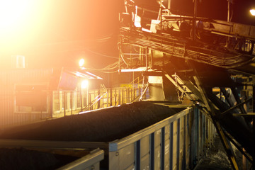railroad cars loaded with coal, the train transports coal. loading of wagons with coal. night views.