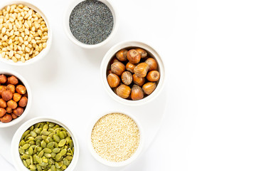 Various Nuts and Seeds on White Background in the Bowls with Free Space for Text