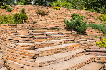 decorative staircase. a stone staircase rises to the mountain slope covered with fallen leaves in autumn