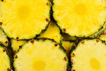 Pineapple juicy yellow slices background. Top view.