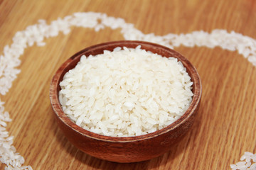 white rice in a wooden plate and rice pattern in the shape of a heart