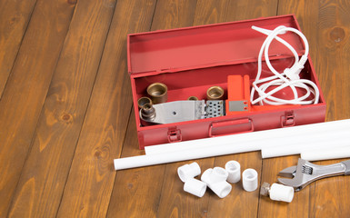 on a dark wooden background, a red box with a soldering iron, a key and a set of nozzles for the...