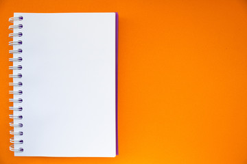 Notepad on an orange background. Place for text