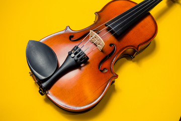 Fototapeta na wymiar Violin with bow isolated on a yellow background. Types of musical instrument