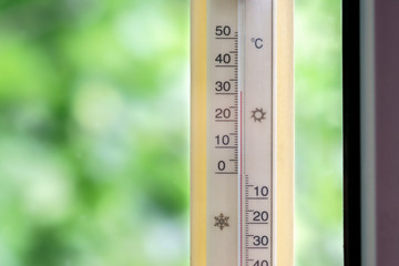 The thermometer outside the window shows hot temperature.