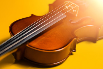 Fototapeta premium Violin with bow isolated on a yellow background. Types of musical instrument