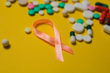 medicines and vitamins. Assortment of pills and capsules isolated on a yellow background. Orange...