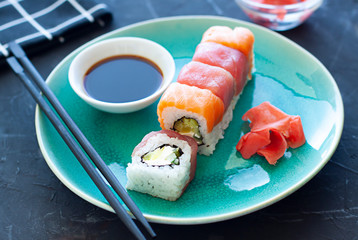 Sushi rolls on the plate with soy sauce and chopsticks. Japanese food close up