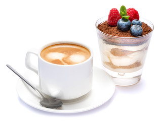 Cup of cofee and Classic tiramisu dessert with blueberries and raspberries in a glass isolated on a white background with clipping path