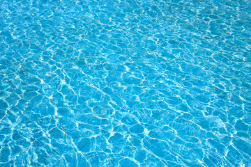 Fototapeta na wymiar Blue color water in swimming pool rippled water with sun reflections background.