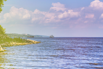 Cargo barge and pleasure craft on the fairway of the river. River navigation on the Volga River.