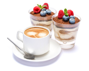 Cup of cofee and Classic tiramisu dessert with blueberries and raspberries in a glass isolated on a white background with clipping path