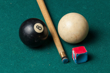 Old billiard ball 8 and stick on a green table. billiard balls isolated on a green background.Black...