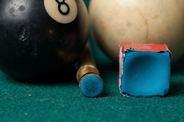 Old billiard ball 8 and stick on a green table. billiard balls isolated on a green background.Black...