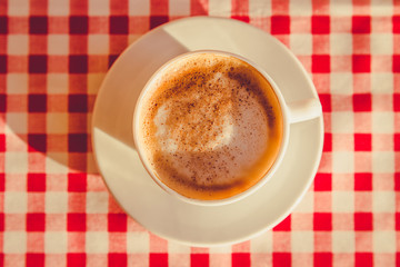 A Cup of cappuccino is on the table in the cafe 
